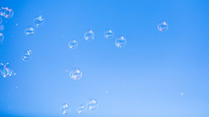 Soap bubbles in flight against the blue sky