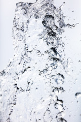 Splashing water with drops on the sky background