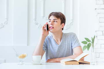 Young man drinking coffee and having breakfast