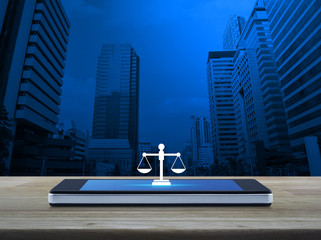 Law flat icon on modern smart mobile phone screen on wooden table over office city tower and skyscraper, Business legal service online concept