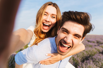 Obraz premium Piękna młoda para przy selfie w lawendzie