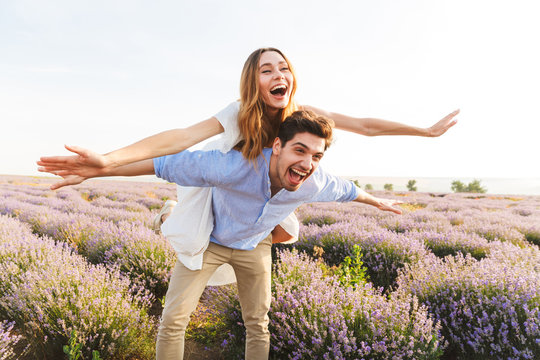 Happy young couple having fun at the lavender field together