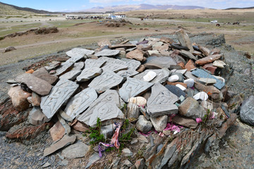 Buddhist prayer stones with Tibetan inscriptions and ritual drawings on the trail from the town of Dorchen around mount Kailash