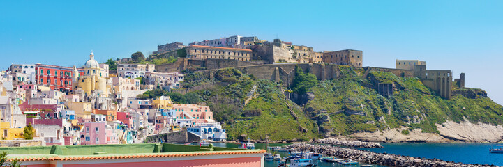 Fototapeta na wymiar Panoramic view of of Marina Corricella and Terra Murata in sunny summer day, Procida island, Italy