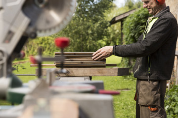 Senior men preparing wood materials with rotary saw