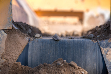 Obraz premium Rock filtering conveyor belt at a quarry. Pebbles and gravel falling out of a filtering facility onto a conveyor belt 