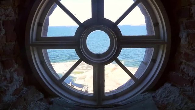 View of endless sea, from a round window, inside a huge lighthouse, on bengtskar island, on a summer day, in saaristomeri national park of the finnish archipelago, in Varsinais-suomi, Finland