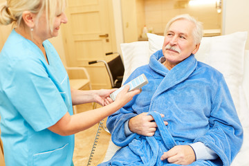 Krankenpflegerin kümmert sich um einen Senior