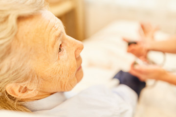 Obraz na płótnie Canvas Senior Frau als Patient bei Blutdruckmessung