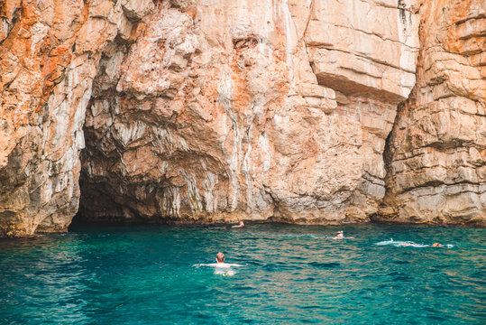 man swimming on back in blue transparent sea water