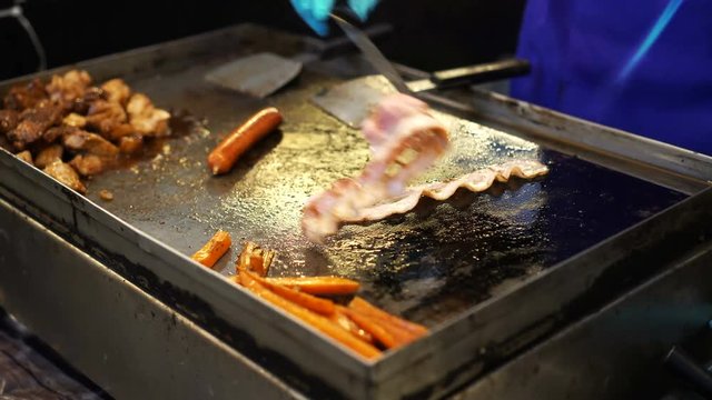 Chef cooking bacon with fire torch in festival food booth video