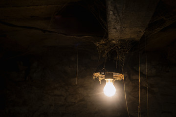 Light of old lamp in a creepy room with cobwebs