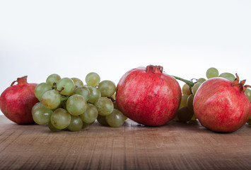 pomegranates and grapes on a white background