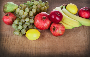 pomegranates and other fruits on a wooden table