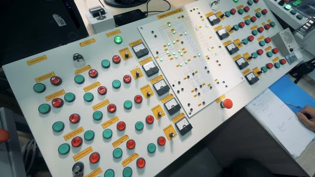 A man pushes buttons on a dashboard, close up.