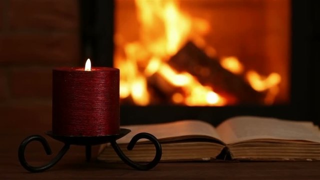 Reading an old book at the fireplace - hand turning page