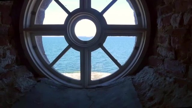 Pan view of endless sea, from a round window, inside a huge lighthouse, on bengtskar island, on a summer day, in saaristomeri national park of the finnish archipelago, in Varsinais-suomi, Finland
