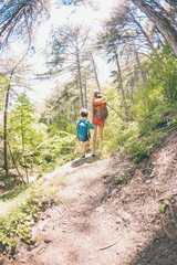 A woman and her child walk along a forest trail.