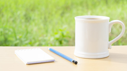 Hot coffee in the morning write new ideas .Props decorations a blue pencil on wooden table nature background,Copy Space..