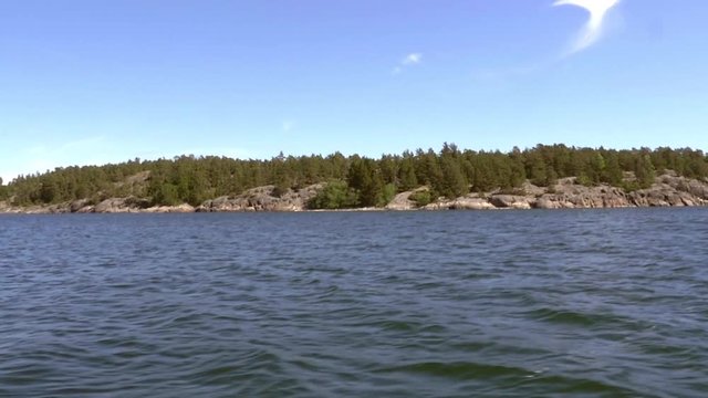 Pov sideway view from a boat of fresh green, summer islands, in saaristomeri national park, in the finnish archipelago, on a sunny day, in Varsinais-suomi, Finland