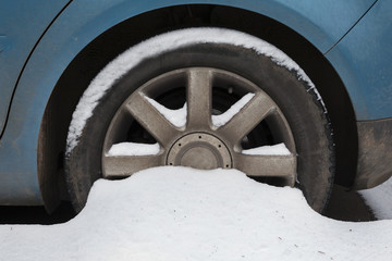 Car wheel covered in snow