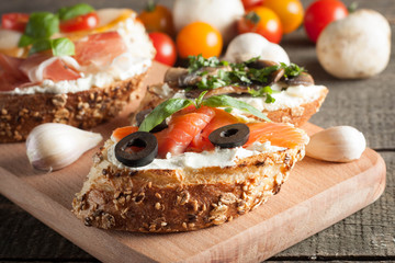Italian tomato and cheese bruschetta. Tapas, antipasti with chopped vegetables, herbs and oil on grilled ciabatta and baguette bread.