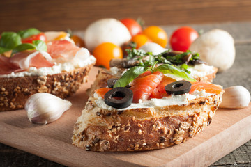 Italian tomato and cheese bruschetta. Tapas, antipasti with chopped vegetables, herbs and oil on grilled ciabatta and baguette bread.