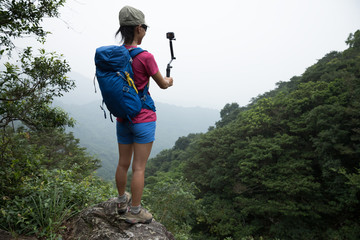 Woman Hiking In Forest Taking A Selfie with action camera