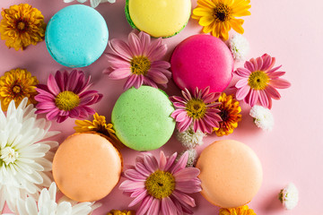 Still life and food photo of cake macarons in a gift box with flowers, a cup of tea on light background. Sweets and desserts concept of macaroons.
