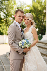 Wedding couple. Portrait of happy beautiful newlyweds, bride and groom standing near the church at...