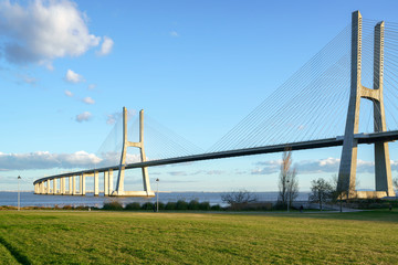 Blick auf die Brücke Ponte Vasco da Gama von einem Gartenpark während des Tages