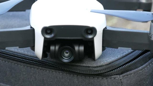 White quadrocopter drone or standing on the bag on nature close up view