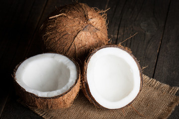 Ripe half cut coconut on a wooden background.  Coconut cream and oil.