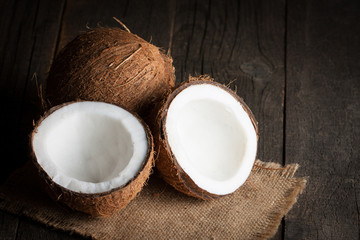 Ripe half cut coconut on a wooden background.  Coconut cream and oil.