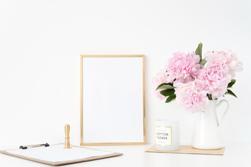 Modern gold portrait a4 frame mock up with a bouquet pink peonies in white jug, gold stamp. Overlay...