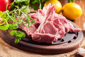 Raw fresh lamb chops on wooden cutting board