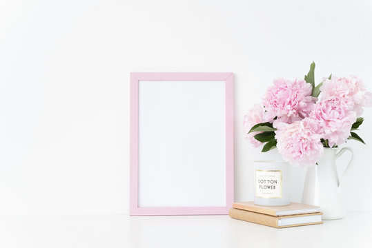 Cute pink portrait a4 frame mock up with a pink peonies in jug beside the frame, overlay your quote, promotion, headline, or design, great for small businesses, lifestyle
