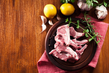 Raw fresh lamb chops on wooden cutting board