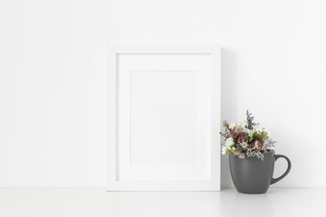 Fototapeta na wymiar White A5 portrait frame mockup with cute bouquet of dried flowers pot on white wall background. Empty frame, poster mock up for presentation design. Template frame for text, lettering, modern art.