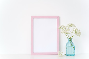 Pink frame a4 mock up with a Aegopodium in vase. Mockup for quote, design. Template for businesses,bloggers,social media