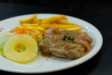 Chicken steak with French fries and salad.