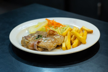 Chicken steak with French fries and salad.