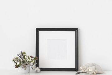 Black square portrait frame mockup with dried field wild flowers in pot and sachet with lavender on...