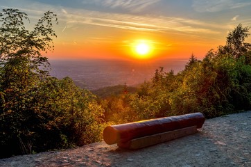 Beautiful colorful landscape. A wooden bench on a mountain trail during sunset.