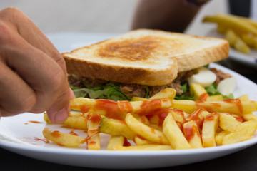 Tuna sandwich and french fries with ketchup combo meal. Fast food menu, lunch at restaurant, healthy eating concepts