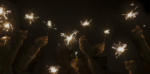 dark night celebrate concept with lot of hands taking and using light sparkles fire together. have...