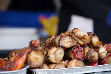 Close up of traditionally grilled pork and beef meat on a wooden stick. Eastern European traditional shish kebab with grilled vegetables.