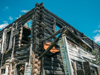 Burned wooden house after fire, ruined building, disaster or war aftermath