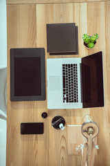 top view of laptop with graphics tablet and smartphone on wooden tabletop at office