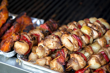 Close up of traditionally grilled pork and beef meat on a wooden stick. Eastern European traditional shish kebab with grilled vegetables.